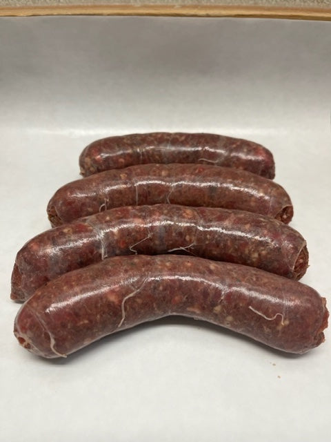 Four links of fresh beef sausages on white butcher paper
