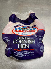 Cornish Hen wrapped in package by bell & evans with details of excellent hens on a metal cutting board. 