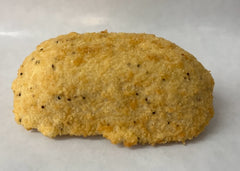 A breaded chicken patty with a golden-brown crust and visible seeds of spices or herbs on the surface.
