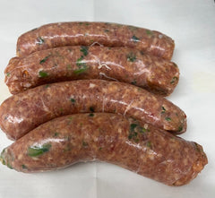 Four raw pork sausage with Broccoli Rabe links on a white butcher paper