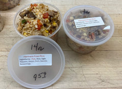 Two containers of Herman's Fried Rice on a wooden surface
