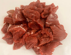 Raw beef chunks on a white background