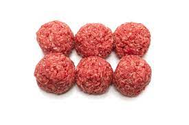 Six raw meatballs on white background.