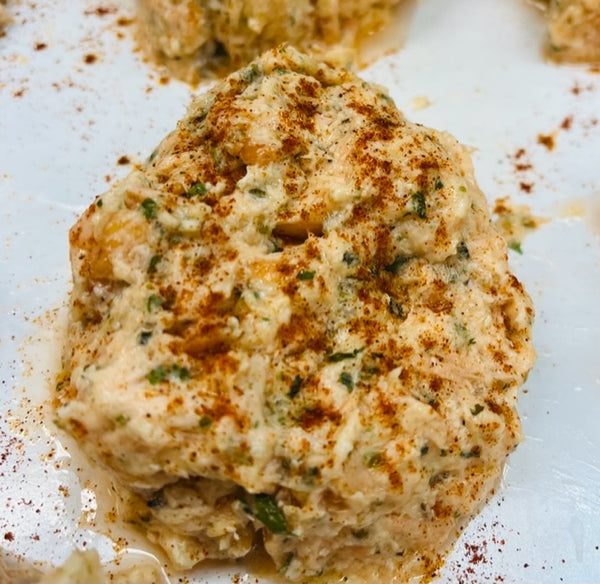 raw salmon cake with seasoning on white butcher paper