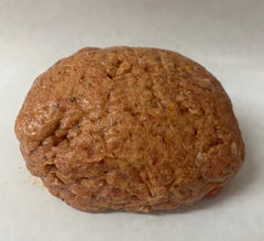 Ball of ground turkey on a white surface.