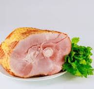A slice of fresh unsmoked ham served on a plate with parsley.
