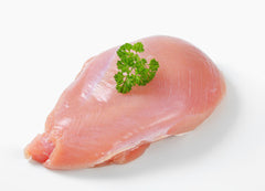 A single, boneless, fresh turkey breast with a piece of parsley on it, presented on a white background.