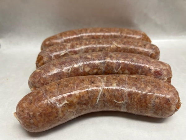 Four raw andouille sausages next to each other on a white surface. 