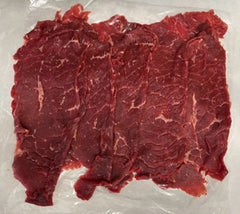 A packaged raw beef roll-up, visible through the transparent plastic wrapping.