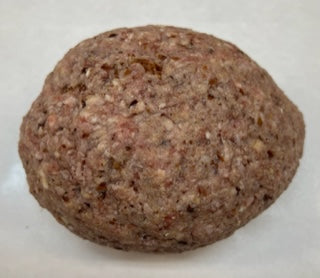 A round, fresh ham loaf on a white butcher paper