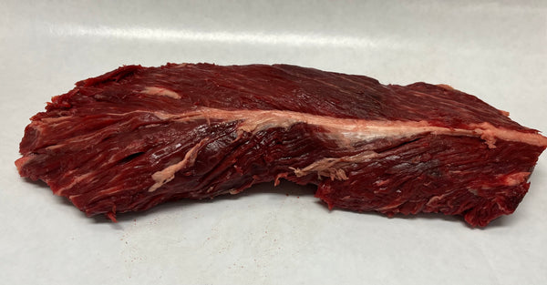 A hanger steak on a white butcher paper, displaying its raw, red meat texture.