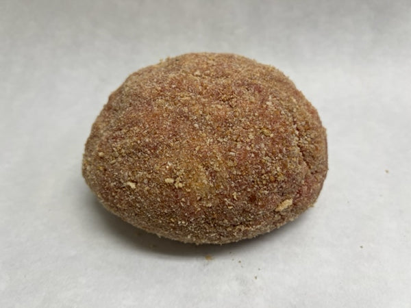 Ball of raw meat loft with visible bread crumbs on outside on a white surface. 