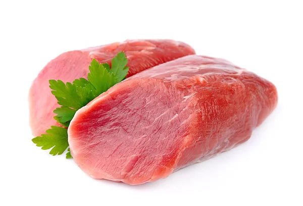 2 pieces of raw lamb roast with parsley on white butcher paper