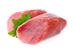 2 pieces of raw lamb roast with parsley on white butcher paper