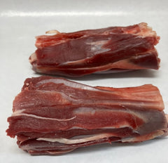 Two raw lamb shanks on a white butcher paper