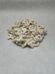 A round prepared Macaroni salad on a white surface, with visible noddles.