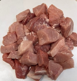 Group of cubed pork  on a white butcher sheet. 