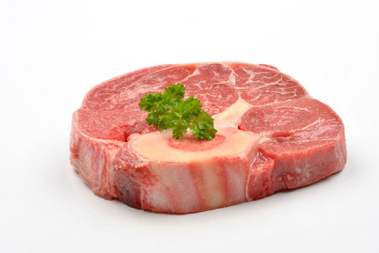 Bone in raw beef shin meat on white butcher paper