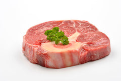 Bone in raw beef shin meat on white butcher paper