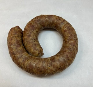 smoked kielbasa roll in a wrapped around its self on a white surface. 