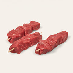 Three skewers of cubed steak with bamboo stick