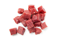Raw beef steak cubes on a white background