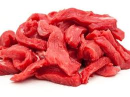 A pile of fresh, raw beef stir fry cuts on a white background.