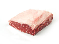A raw beef strip loin roast on a white butcher paper