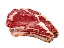 A raw beef ribeye bone in steak on a white butcher paper.