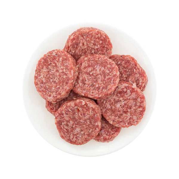 A white bowl containing fresh pork sausages.