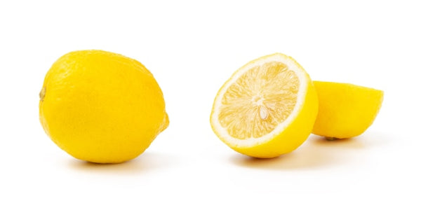 Yellow fresh lemon next to a slice lemon in half with a white background. 