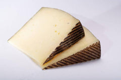 Chucks of manchego cheese on white surface. 