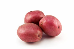 Three red potatoes on a white background.