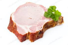 center cut pork chop on a white background and green herb