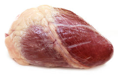 Raw veal heart on flat white table.