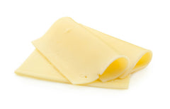 Slices of white cheddar on white surface.